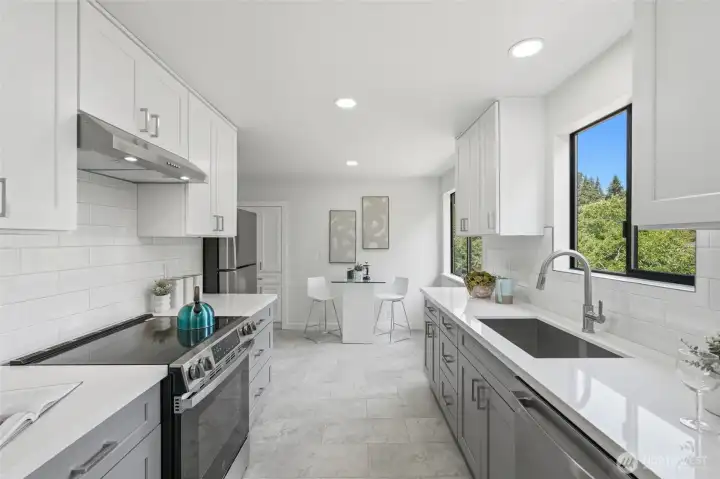 The brand new kitchen with a breakfast nook features clean, modern lines and stainless steel appliances.