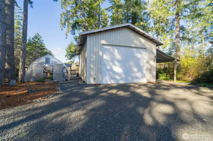 The 24' x 36' shop is perfect for an RV or large boat! There is a wonderful green house to the left and another carport to the right.