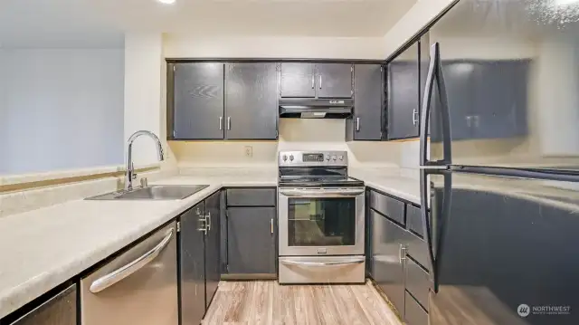 Galley style kitchen with stainless appliances and rich cabinetry offering ample storage space.
