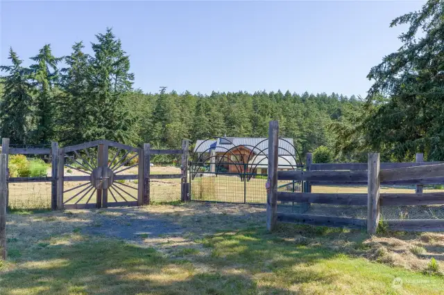 Gates into the approx 2 deer fenced acres with main home, greenhouse, garden & orchard.