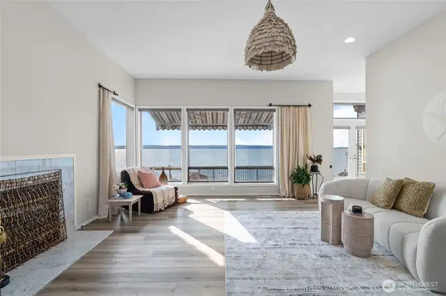 Tall windows with vaulted ceilings on living room looking to water views with elecrtic awning
