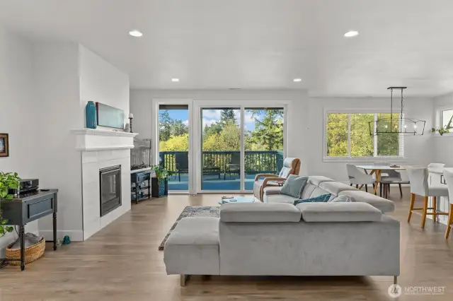 Gather with ease in this open-plan living space, where warm sunlight and tree-lined valley views pour in through large windows and slider.