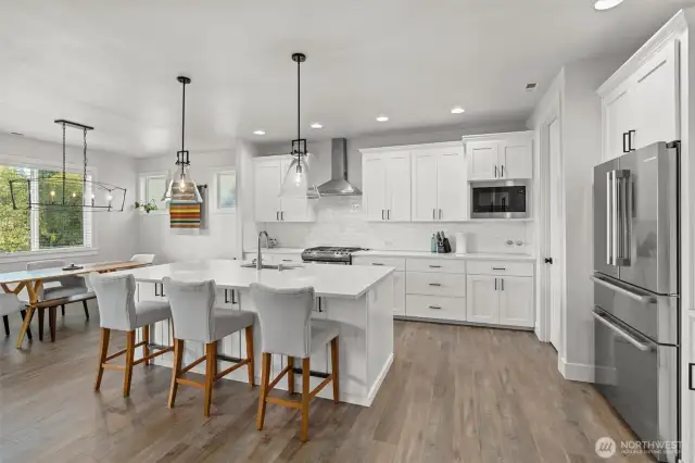 This chef’s kitchen is the heart of the home—featuring crisp white cabinetry, sleek stainless steel appliances, and a spacious island perfect for meal prep or casual gatherings.