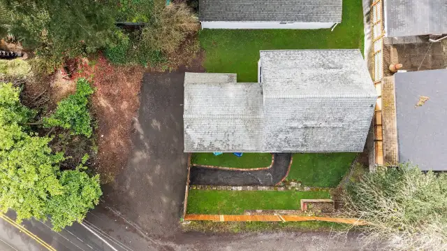 Aerial view featuring additional off-street parking spots and fully fenced yard.