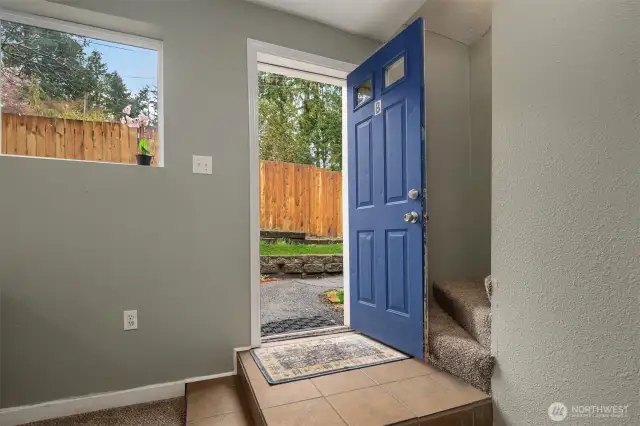 Front door opening to fully fenced yard.