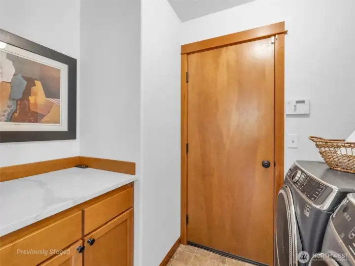 Laundry/mudroom off the garage has newer washer and dryer and great space for folding clothes and storing cleaning supplies