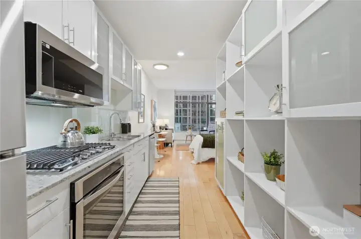 Stunning kitchen area with everything you need; gas cooktop, built in-oven, microwave & dishwasher & plus wonderful size refrigerator.  Plenty of kitchen cabinet storage plus the built-in shelving for more space!