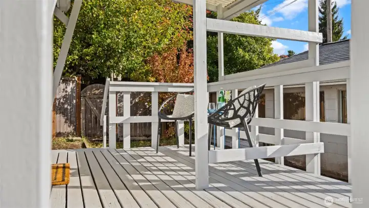 Another angle of the back deck and garage shows off just how private this property feels. The mature trees along the edge create a natural green backdrop - perfect for relaxing outdoors or hosting a quiet evening under the canopy.