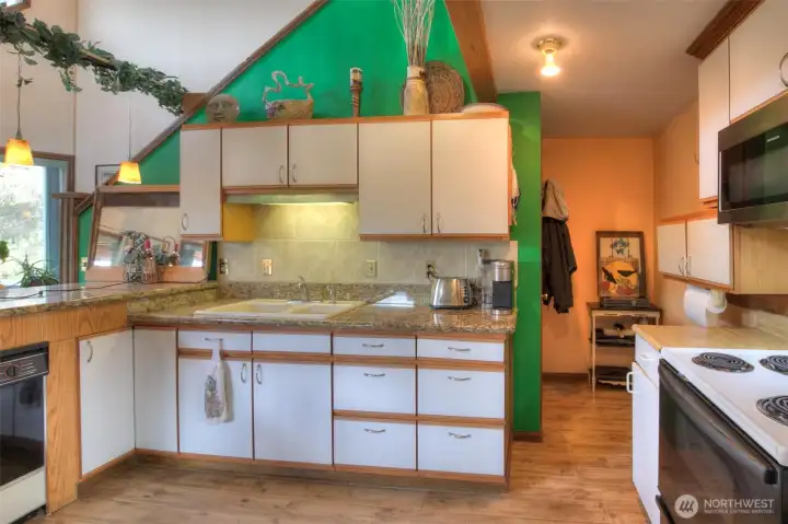 Granite kitchen countertops, glazed porcelain tile flooring and cedar trim.