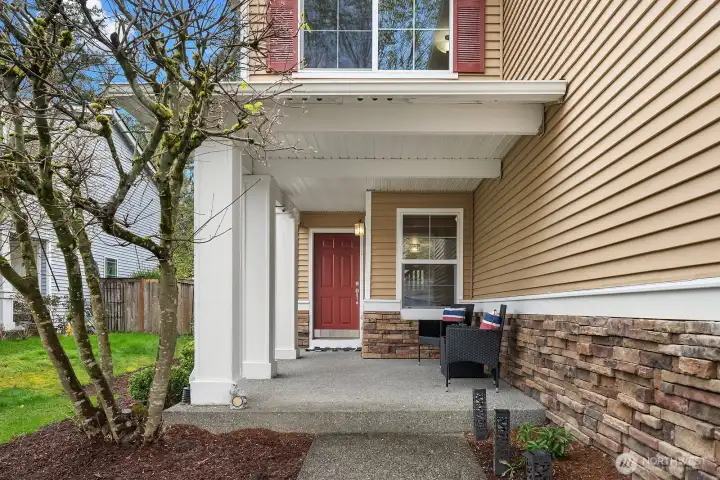 This welcoming covered front entry features charming architectural details including elegant columns, classic stone accents, and a bold red door that creates a warm and inviting first impression. The thoughtfully designed entry porch provides a sheltered and gracious transition into this exceptional Norris Estates home.