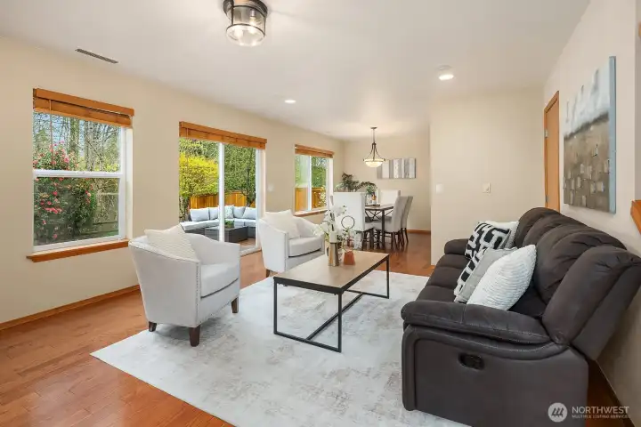 This alternate view of the living room further highlights the generous proportions, gleaming hardwood floors, and abundance of natural light that make this space so warm and welcoming. The open flow to the dining area and kitchen beyond, combined with the designer finishes throughout, creates a seamlessly connected main level perfectly suited for modern everyday living.
