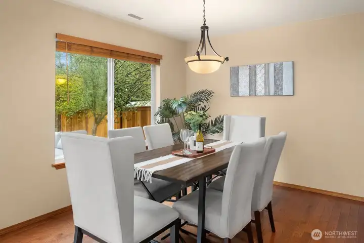 The elegant dining room features rich hardwood floors, a stylish chandelier, and a large window overlooking the peaceful backyard, creating a bright and sophisticated setting for both everyday meals and special occasions. Generously sized and seamlessly connected to the main living areas, this inviting space is perfectly suited for entertaining family and friends in style.
