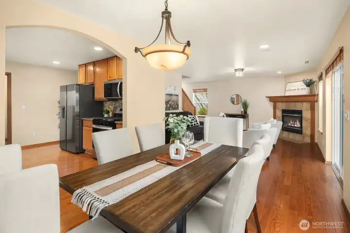 This inviting view captures the seamless open-concept flow from the dining room straight through to the kitchen beyond, with gleaming hardwood floors, a elegant chandelier, and an abundance of natural light unifying the spaces beautifully. The connected layout makes this combination ideal for effortless entertaining, keeping the chef engaged with guests from kitchen to table with ease.