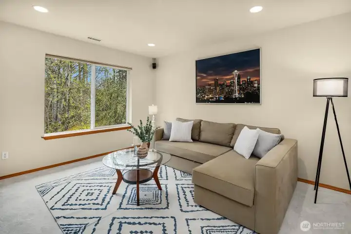 Bright and inviting living room featuring rich hardwood floors, designer paint, and large windows that flood the space with natural light — the perfect place to gather and unwind.