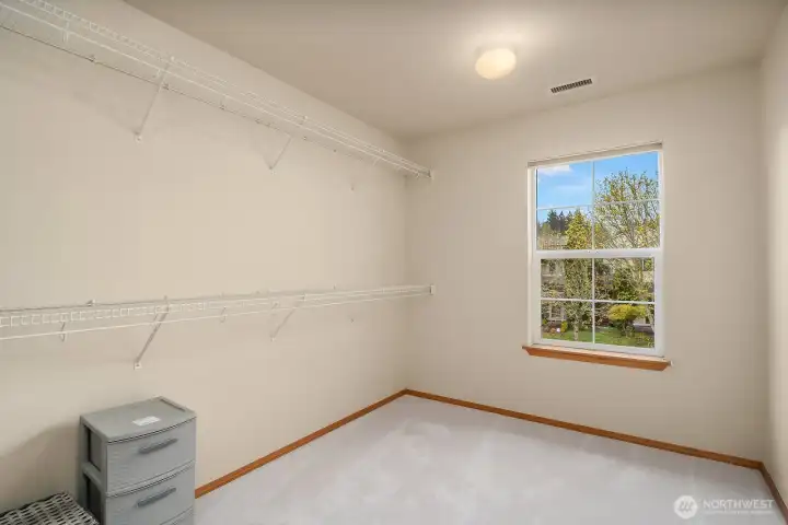 The spacious walk-in closet off the primary suite offers plenty of room for customization and storage, with fresh neutral walls and natural light creating a clean and functional space.