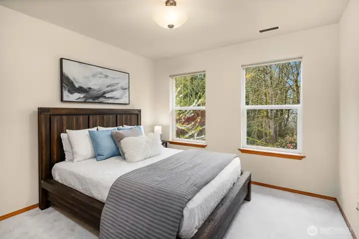 A generously sized secondary bedroom featuring plush carpet, freshly painted walls, and lovely natural light — complete with a walk-in closet to keep everything neat and organized.