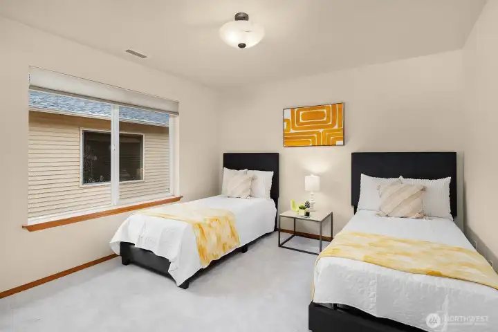 Another generously sized bedroom offering ample space for twin beds, fresh neutral walls, and plenty of natural light — a versatile and welcoming room with walk-in closet storage.