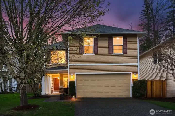 This charming Norris Estates home makes a wonderful first impression with its classic two-story facade, welcoming covered entry, and beautifully maintained landscaping framed by a mature flowering tree in full bloom. The attached two-car garage, fresh exterior finishes, and warm evening lighting combine to create an inviting curb appeal that perfectly sets the stage for the exceptional home within.