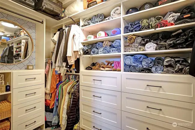 Primary walk-in closet with custom closet system.