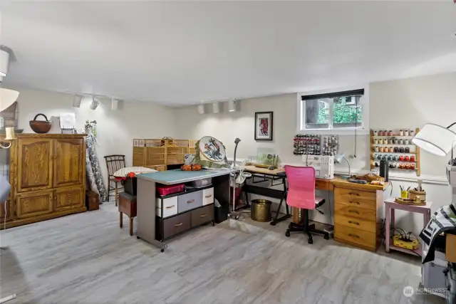 Fully-finished basement features a large bonus living space, currently being used as a craft and hobby space. This space and the small unfinished space next to it could become another kitchen/living room.
