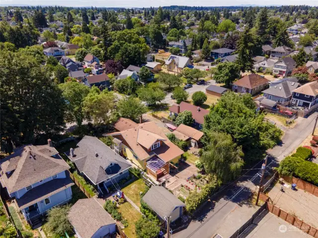 Back aerial view of property and surrounding neighborhood, take notice of all the mature landscaping and trees nearby.