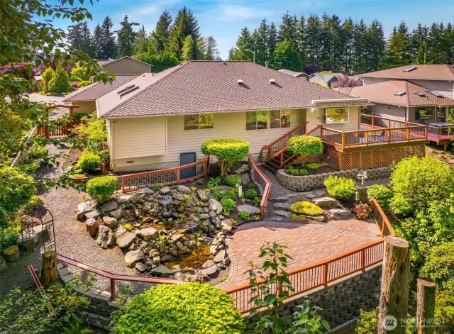 Step outside to a peaceful, park-like backyard with a generous deck, perfect for summer barbecues or relaxing  under the trees.