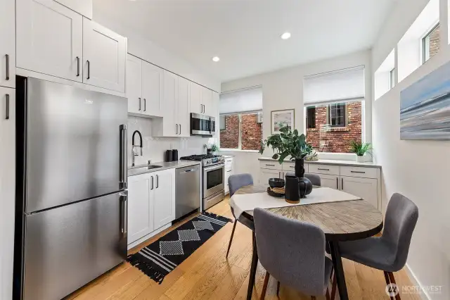Kitchen has space for dining table and big windows overlooking a cool brick wall.