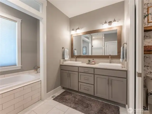 Elegant Primary Suite – Features dual walk-in closets, a luxurious 5-piece bath with soaking tub, tile shower, double vanities, and a private water closet for ultimate comfort and privacy.