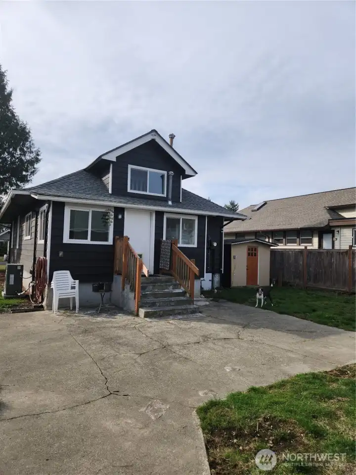 Back view of the home with large patio and shed