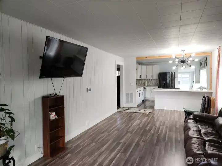 View of living room, to the left is hallway to 2 bedrooms and bathroom.  Kitchen in view.