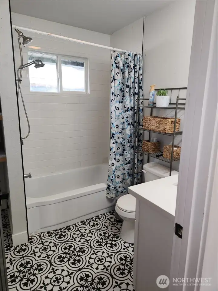 Between the two rooms downstairs is this beautiful bathroom with beautiful tiled flooring and shower.