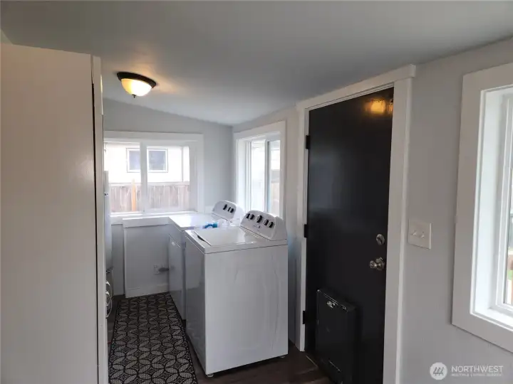 Utility room off the kitchen, washer and dryer and installed storage stays.  Notice the doggy door for convenience, if you have pets.