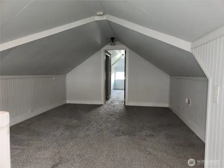 At the top of the stairs is this spacious bonus room you could make into a media or TV room.  Bedroom 3 is in view through the doorway.