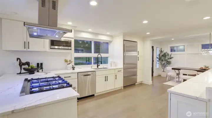 Gourmet kitchen features a peninsula with eating bar and a premium gas range.