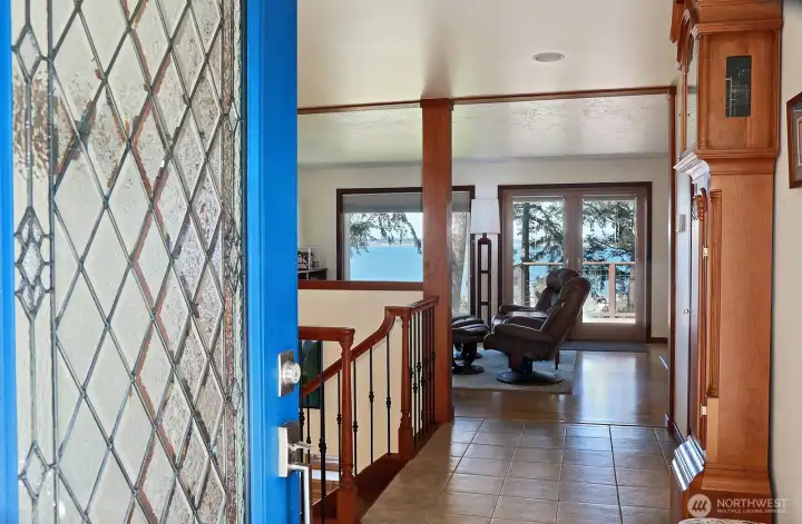 Take in the view as you enter via the main front door! Ceramic tiled foyer with a coat closet to your right (not in photo), living room straight ahead, left to the hallway to primary suite, office & laundry, to your right, kitchen & dining.