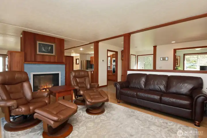 Looking back from the water side of the living room. Dual-sided propane fireplace w/ custom cherry mantel and buit-in book shelves. The Dining Area is on the other side of the fireplace. You can see the office to the far right.
