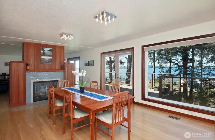 Spacious Dining Area with the dual-sided fireplace. You can see the third set of French doors (living room) in this photo. It's hard to forget you live waterside in this home!
