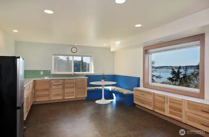 The fireplace is now to your back and you are looking back at the kitchenette area with plenty of built in storage and plenty of windows to keep your view constant.