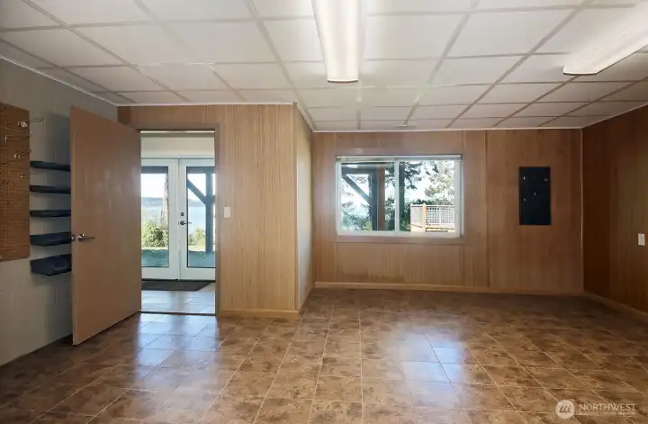 We are now in the workshop (would make an excellent rec room) looking through the open door to the lower level entry way. There is a built in bench in the lower level entry way.