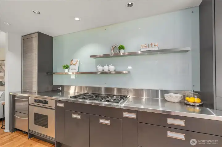 Sleek European-inspired design with stainless steel countertops, a commercial-grade gas cooktop
