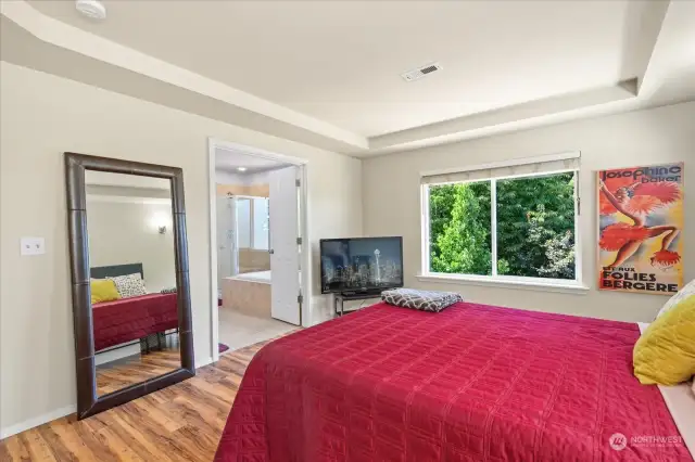 Large primary bedroom with French doors to the large ensuite bathroom.