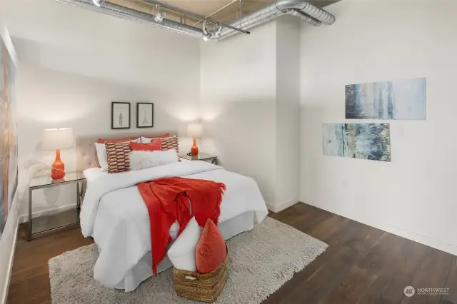 The bedroom invites relaxation while maintaining the unit's modern loft style, offering both style and comfort for urban living.