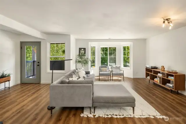 Open, airy living room with bay window and balcony perfect for a bistro set and morning coffee.