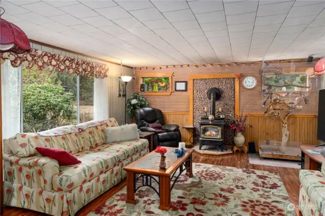 Living room features large window and propane stove.