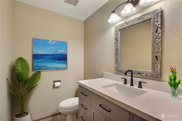 Main level powder room. Digitally staged.