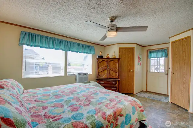 Main bedroom with two walk-in closets and door to outside private deck.