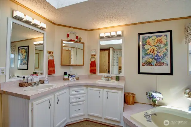 Main bathroom is spacious and has lots of natural light with windows and skylight overhead.