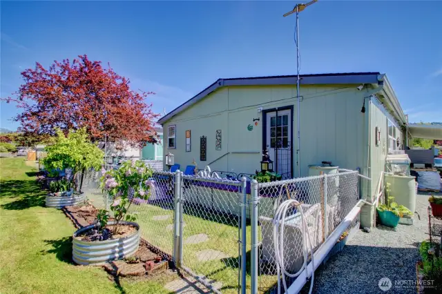 This area is at the back of the home. Fenced and landscaped. Water barrels used for watering.