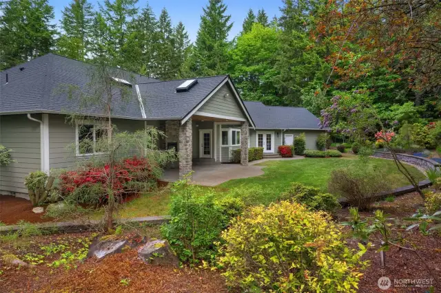 Beautiful mature landscaping. A view of the covered back patio.