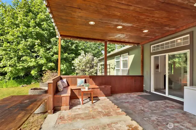 The updated covered patio has beautiful built-in seating and is ideal for relaxing or hosting year-round.